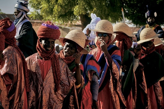 Zaria city Nigeria 21 March 2026 View of a vibrant procession of figures in richly colored robes striking straw hats and intricate headwear. Zaria city Nigeria 21 March 2026 View of a vibrant procession of figures in richly colored robes striking straw hats and intricate headwear.