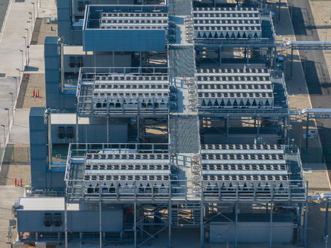 Aerial view of a large industrial datacenter featuring rows of cooling units and metal infrastructure in The Netherlands. Aerial view of a large industrial datacenter featuring rows of cooling units and metal infrastructure in The Netherlands.