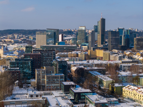 Aerial view of modern skyscrapers and snow covered rooftops under a clear blue sky in the business district Vilnius County Lithuania.