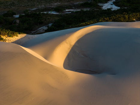 Aerial view of the white sand dunes of Parque Nacional dos Lencois Maranhenses with golden sunlight and deep shadows at sunset Lencois Maranhenses MA Brazil. Aerial view of the white sand dunes of Parque Nacional dos Lencois Maranhenses with golden sunlight and deep shadows at sunset Lencois Maranhenses MA Brazil.