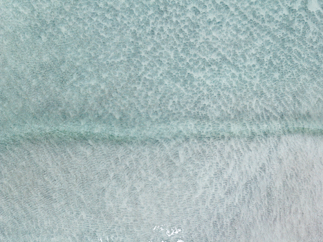 Aerial view of clear turquoise water with intricate sand ripples and patterns along the coast of the Lofoten islands in Svolvaer Nordland Norway.