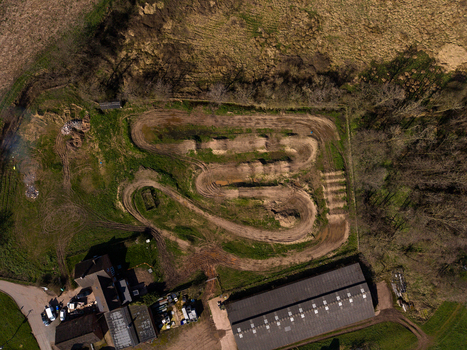 Aerial view of Gnosall Heath motocross track with dirt paths surrounding fields and farm buildings in Gnosall England United Kingdom. Aerial view of Gnosall Heath motocross track with dirt paths surrounding fields and farm buildings in Gnosall England United Kingdom.