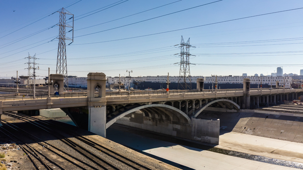 Aerial view of the 6th Street Viaduct spanning the Los Angeles River featuring iconic arches concrete structure and railway tracks in Los Angeles California United States.