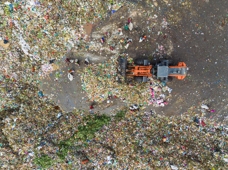 Aminbazar Bangladesh 26 January 2025 Aerial view of Aminbazar landfill with an orange bulldozer moving plastic waste and waste pickers collecting materials. Aminbazar Bangladesh 26 January 2025 Aerial view of Aminbazar landfill with an orange bulldozer moving plastic waste and waste pickers collecting materials.