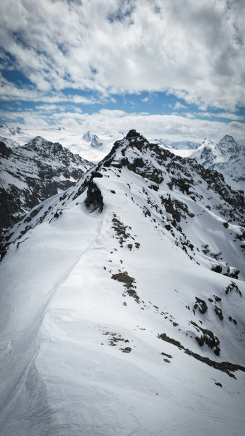 Aerial view of snow capped peaks under a sky streaked with clouds Mount Colmet Arpy Valle d Aosta Italy. Aerial view of snow capped peaks under a sky streaked with clouds Mount Colmet Arpy Valle d Aosta Italy.