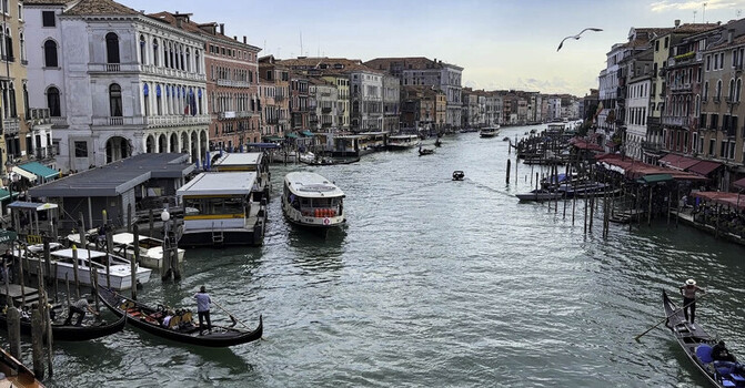View of the Grand Canal in Venice with traditional gondolas water taxis and historic buildings lining the waterway in Venice Italy. View of the Grand Canal in Venice with traditional gondolas water taxis and historic buildings lining the waterway in Venice Italy.