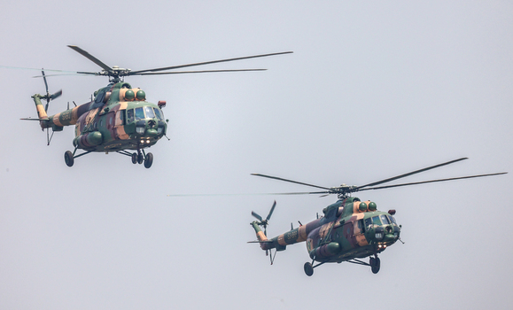 Dhaka Bangladesh 25 March 2026 View of two military helicopters soaring through the pale sky their camouflage blending with the ethereal haze.