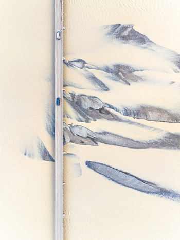 Aerial view of a bridge crossing a glacial river with intricate sediment patterns and braided channels in Iceland. Aerial view of a bridge crossing a glacial river with intricate sediment patterns and braided channels in Iceland.