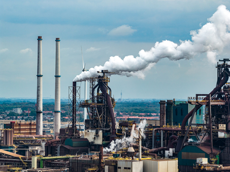 Aerial view of the Tata Steel industrial plant with tall chimneys emitting smoke and complex metal structures in Velsen Noord Noord Holland Netherlands. Aerial view of the Tata Steel industrial plant with tall chimneys emitting smoke and complex metal structures in Velsen Noord Noord Holland Netherlands.