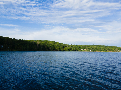 Aerial view of Commanda Lake surrounded by dense green forests under a blue sky in Restoule Ontario Canada. Aerial view of Commanda Lake surrounded by dense green forests under a blue sky in Restoule Ontario Canada.