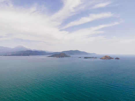 Aerial view of the coastal landscape near Karaot Beach featuring turquoise waters small islands and distant mountains under a bright sky in Fethiye Mugla Turkiye. Aerial view of the coastal landscape near Karaot Beach featuring turquoise waters small islands and distant mountains under a bright sky in Fethiye Mugla Turkiye.