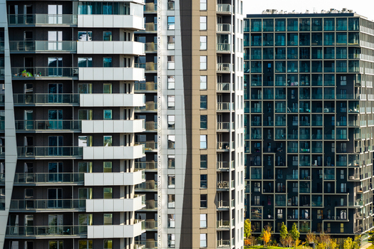 Aerial view of modern residential real estate featuring high rise apartment buildings with glass facades balconies and geometric architectural details Katowice Silesian Voivodeship Poland.