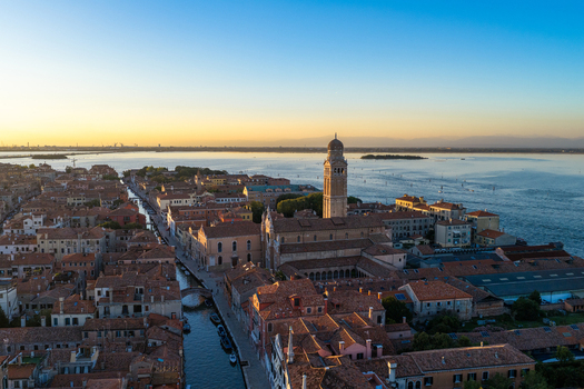 Aerial view of the historic city of Venice with its iconic terracotta rooftops narrow canals and the prominent bell tower of San Pietro di Castello in Venice Veneto Italy. Aerial view of the historic city of Venice with its iconic terracotta rooftops narrow canals and the prominent bell tower of San Pietro di Castello in Venice Veneto Italy.