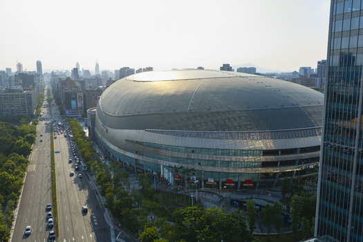 Aerial view of the Taipei Dome stadium with its distinctive curved roof surrounded by urban streets and greenery in Taipei Taiwan. Aerial view of the Taipei Dome stadium with its distinctive curved roof surrounded by urban streets and greenery in Taipei Taiwan.