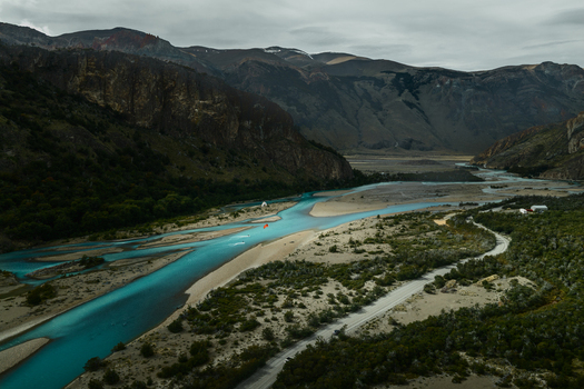 Aerial view of the turquoise river winding through the rugged mountainous landscape of El Chalten Santa Cruz Province Argentina. Aerial view of the turquoise river winding through the rugged mountainous landscape of El Chalten Santa Cruz Province Argentina.