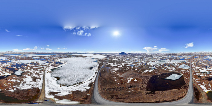 Aerial view of the frozen landscape of Lake Myvatn with winding roads and snow covered ground under a bright sun in Myvatn THingeyjarsveit Iceland.