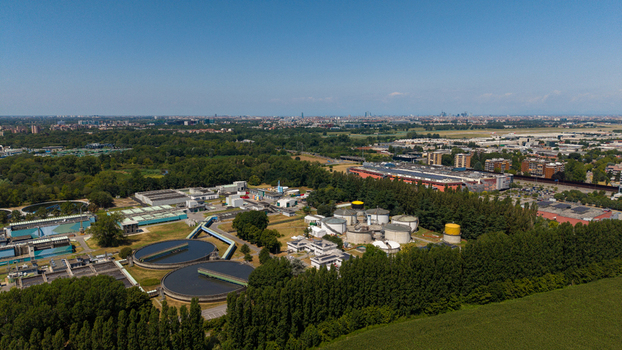 Aerial view of a wastewater treatment plant with circular settling tanks and industrial facilities surrounded by green trees and fields near Milan Lombardy Italy. Aerial view of a wastewater treatment plant with circular settling tanks and industrial facilities surrounded by green trees and fields near Milan Lombardy Italy.