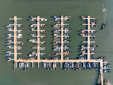 Aerial view of boats neatly docked in the harbor of Porta de Abrigo da Torreira the water reflecting the sky Porta de Abrigo da Torreira Aveiro Portugal.