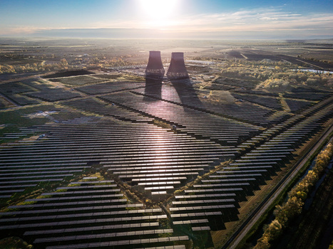 Trino Italy 30 March 2026 Aerial view of solar panels mirroring the colossal cooling towers under the warm glow of the rising sun a testament to power and innovation. Trino Italy 30 March 2026 Aerial view of solar panels mirroring the colossal cooling towers under the warm glow of the rising sun a testament to power and innovation.