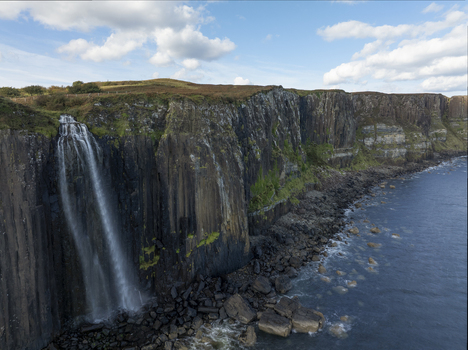 Aerial view of Mealt Falls cascading over dramatic basalt cliffs into the sea along the rugged coastline of the Isle of Skye Scotland United Kingdom. Aerial view of Mealt Falls cascading over dramatic basalt cliffs into the sea along the rugged coastline of the Isle of Skye Scotland United Kingdom.