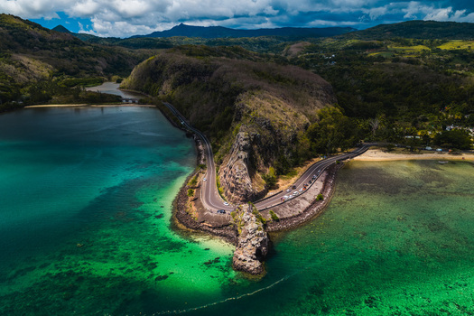 Aerial view of the Maconde Viewpoint and the winding coastal road along the turquoise lagoon and lush green mountains in Moka District Mauritius. Aerial view of the Maconde Viewpoint and the winding coastal road along the turquoise lagoon and lush green mountains in Moka District Mauritius.