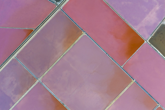 Aerial view of the pink and red hues of the salt flats create a stunning geometric mosaic from above San Pedro del Pinatar Region of Murcia Spain. Aerial view of the pink and red hues of the salt flats create a stunning geometric mosaic from above San Pedro del Pinatar Region of Murcia Spain.