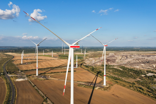 Aerial view of wind turbines standing in agricultural fields near the Schleenhain lignite open cast mine under a clear blue sky Zwenkau Saxony Germany.