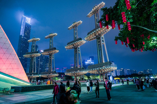 Guangzhou Guangdong Province China 24 February 2024 View of the illuminated modern structures and red lanterns in Flower City Square with people walking at night. Guangzhou Guangdong Province China 24 February 2024 View of the illuminated modern structures and red lanterns in Flower City Square with people walking at night.