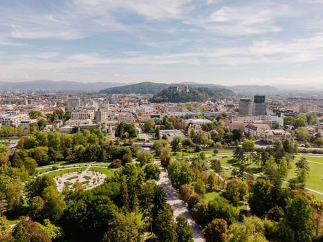 Aerial view of Tivoli Park with its lush green lawns tree lined paths and the cityscape of Ljubljana in the background under a clear blue sky Ljubljana Slovenia.