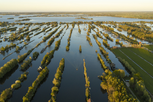 Aerial view of the Scheendijk area featuring narrow strips of land with lush trees and calm waterways in Breukelen Utrecht Netherlands. Aerial view of the Scheendijk area featuring narrow strips of land with lush trees and calm waterways in Breukelen Utrecht Netherlands.