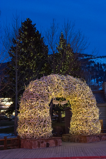 View of the iconic elk antler arch illuminated at twilight in Jackson Hole Teton County Wyoming United States.