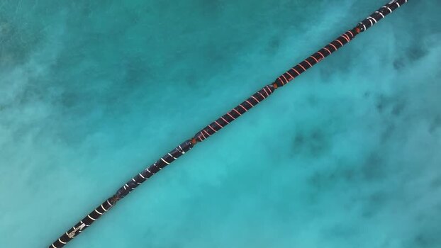 Aerial view of a floating pipe on turquoise water in Maldives.