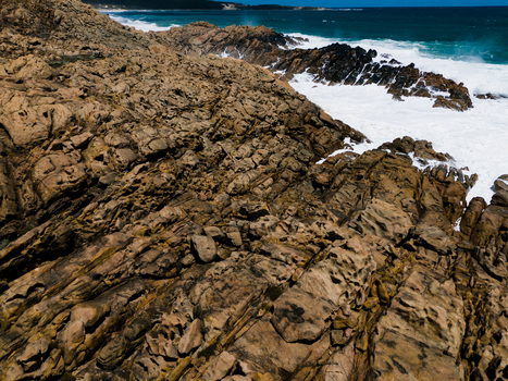 Aerial view of the rugged rock formations at Injidup Natural Spa with crashing turquoise waves and white sea foam along the coastline in Yallingup Western Australia Australia. Aerial view of the rugged rock formations at Injidup Natural Spa with crashing turquoise waves and white sea foam along the coastline in Yallingup Western Australia Australia.