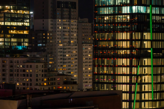 Aerial view of modern offices in the financial district with illuminated glass skyscrapers and glowing windows at night in Warsaw Masovian Voivodeship Poland.