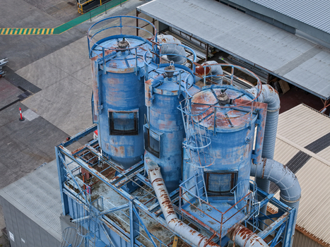 Melbourne Australia 25 September 2026 Aerial view of industrial blue metal silos and dust collection machinery at a factory site with weathered surfaces and metal piping.