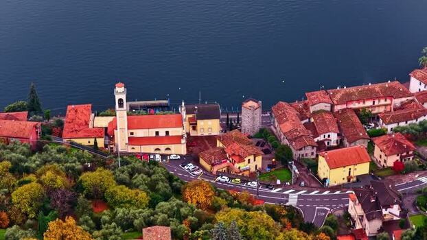 Aerial view of a lakeside village with a church in Italy.