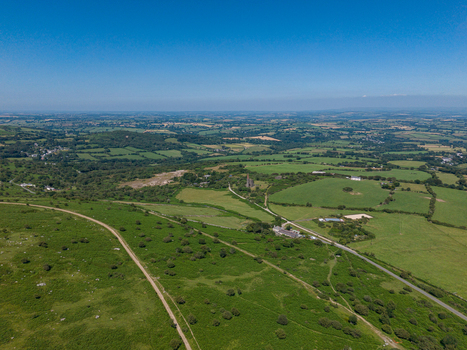 Aerial view of the historic mine engine house surrounded by lush green fields rolling hills and rural landscape in Minions Cornwall United Kingdom. Aerial view of the historic mine engine house surrounded by lush green fields rolling hills and rural landscape in Minions Cornwall United Kingdom.
