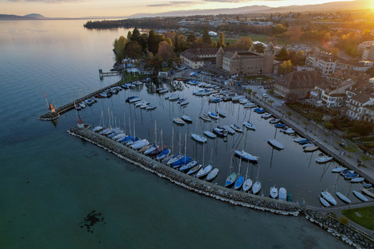 Aerial view of Morges Castle and the marina filled with sailboats on the shores of Lake Geneva during sunset Morges Vaud Switzerland. Aerial view of Morges Castle and the marina filled with sailboats on the shores of Lake Geneva during sunset Morges Vaud Switzerland.