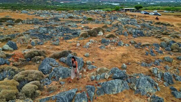Aerial view of woman walking in rocky landscape of Crete Greece.
