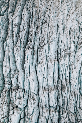 Aerial view of the intricate frozen patterns and deep blue crevasses of the Skaftafell glacier surface in Skaftafell Sveitarfelagid Hornaf Iceland. Aerial view of the intricate frozen patterns and deep blue crevasses of the Skaftafell glacier surface in Skaftafell Sveitarfelagid Hornaf Iceland.