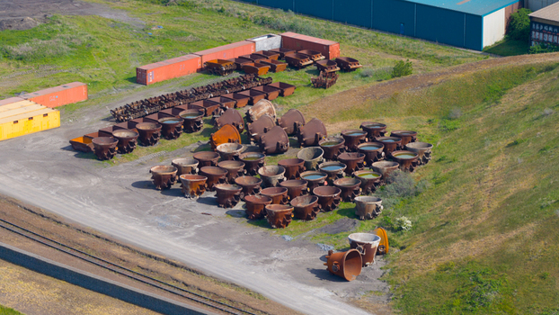 Aerial view of Tata Steel industrial site featuring rows of large metal ladles and shipping containers near a railway track in Velsen Noord Noord Holland Netherlands. Aerial view of Tata Steel industrial site featuring rows of large metal ladles and shipping containers near a railway track in Velsen Noord Noord Holland Netherlands.