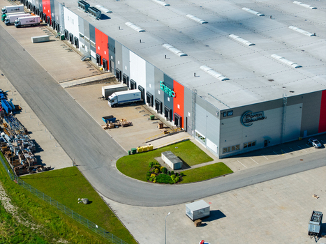 Lielvarzi Latvia 05 July 2026 Aerial view of VGP Park Kekava warehouse showing the large industrial building with loading docks parked trucks and surrounding paved logistics yard under clear daylight. Lielvarzi Latvia 05 July 2026 Aerial view of VGP Park Kekava warehouse showing the large industrial building with loading docks parked trucks and surrounding paved logistics yard under clear daylight.