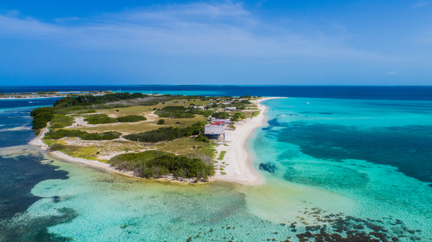 Aerial view of Los Roques archipelago featuring white sand beaches lush vegetation and vibrant turquoise waters under a clear blue sky in Los Roques Dependencias Federale Venezuela. Aerial view of Los Roques archipelago featuring white sand beaches lush vegetation and vibrant turquoise waters under a clear blue sky in Los Roques Dependencias Federale Venezuela.