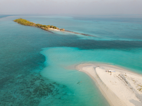 Aerial view of Kan island s white sandy beach meeting the turquoise sea a serene escape in the Maldives Dhidhdhoo Thiladhunmathi Atoll Maldives.
