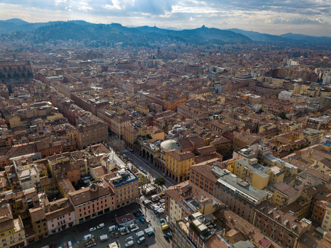 Aerial view of the historic city center with its characteristic red rooftops medieval architecture and rolling hills under a cloudy sky in Bologna Emilia Romagna Italy. Aerial view of the historic city center with its characteristic red rooftops medieval architecture and rolling hills under a cloudy sky in Bologna Emilia Romagna Italy.