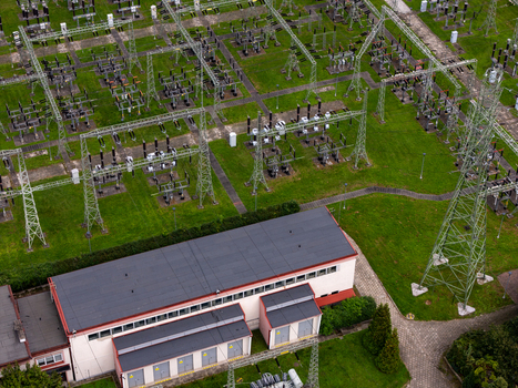 Aerial view of an electrical substation with high voltage power lines metal towers and transformers set amidst green grass in Gdansk Poland. Aerial view of an electrical substation with high voltage power lines metal towers and transformers set amidst green grass in Gdansk Poland.