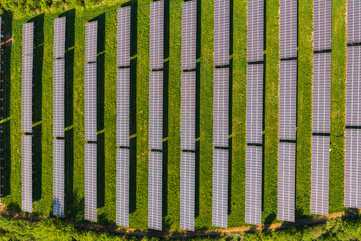 Aerial view of rows of solar panels installed on a lush green field under bright sunlight Kyjov South Moravian Region Czechia.