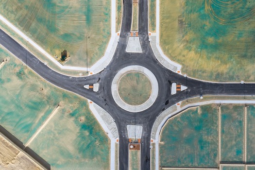 Aerial view of a newly constructed roundabout in a residential development area with asphalt roads and surrounding plots of land in Perth Western Australia Australia. Aerial view of a newly constructed roundabout in a residential development area with asphalt roads and surrounding plots of land in Perth Western Australia Australia.