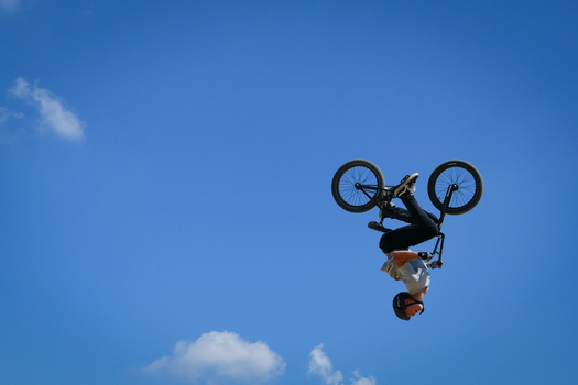 Chichester United Kingdom 14 July 2018 View of a BMX rider executing a daring mid air flip against a backdrop of clear blue skies and scattered clouds at Goodwood Motor Circuit.