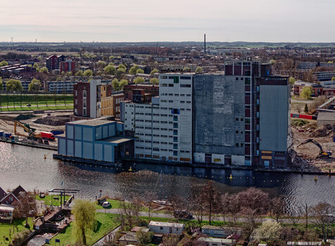 Aerial view of the Meneba Flour Mill standing amidst the water surrounded by signs of demolition a poignant contrast of old and new Wormerveer Netherlands. Aerial view of the Meneba Flour Mill standing amidst the water surrounded by signs of demolition a poignant contrast of old and new Wormerveer Netherlands.